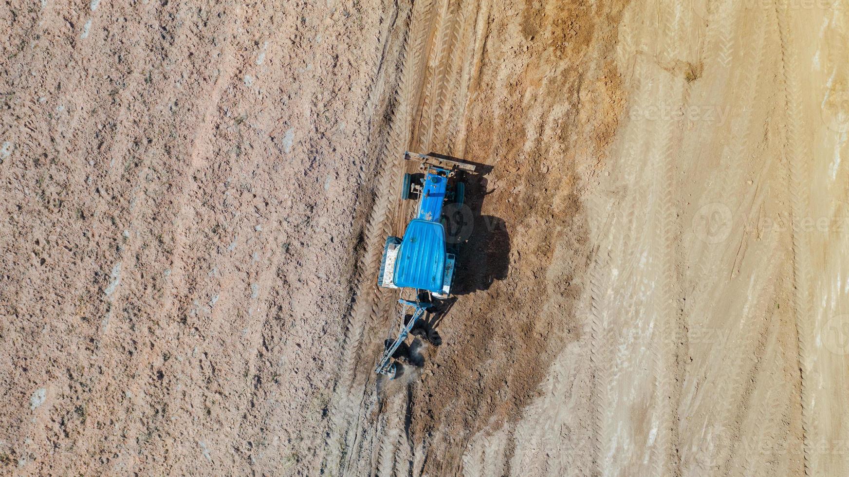 Vista superior de los vehículos tractores agrícolas que trabajan en el campo foto