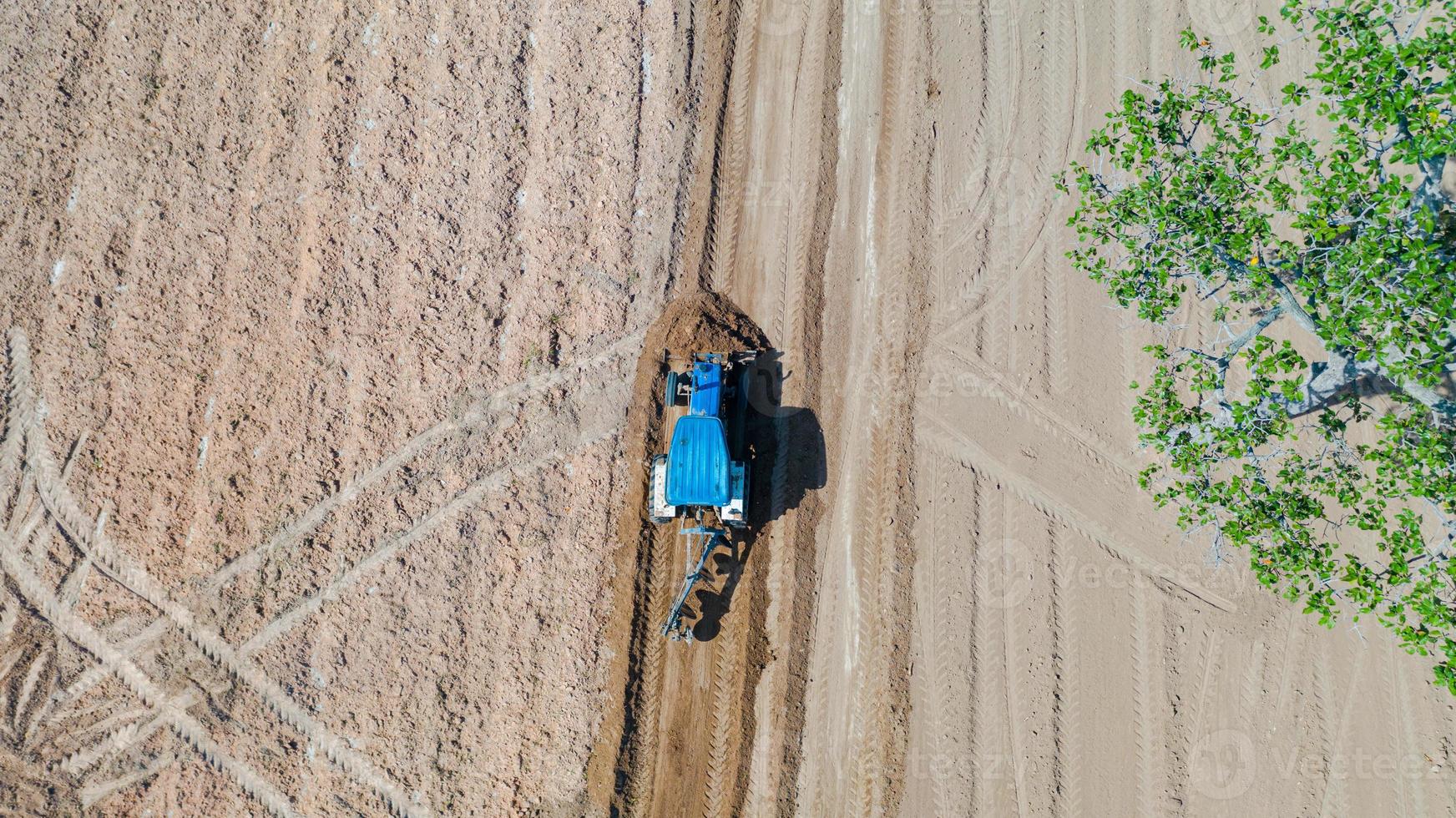 Top view of agricultural tractor vehicles working at field photo