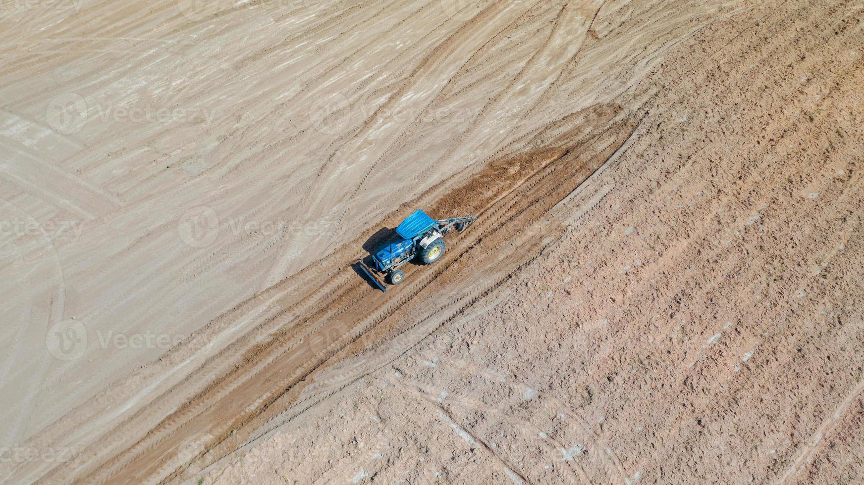 Top view of agricultural tractor vehicles working at field photo