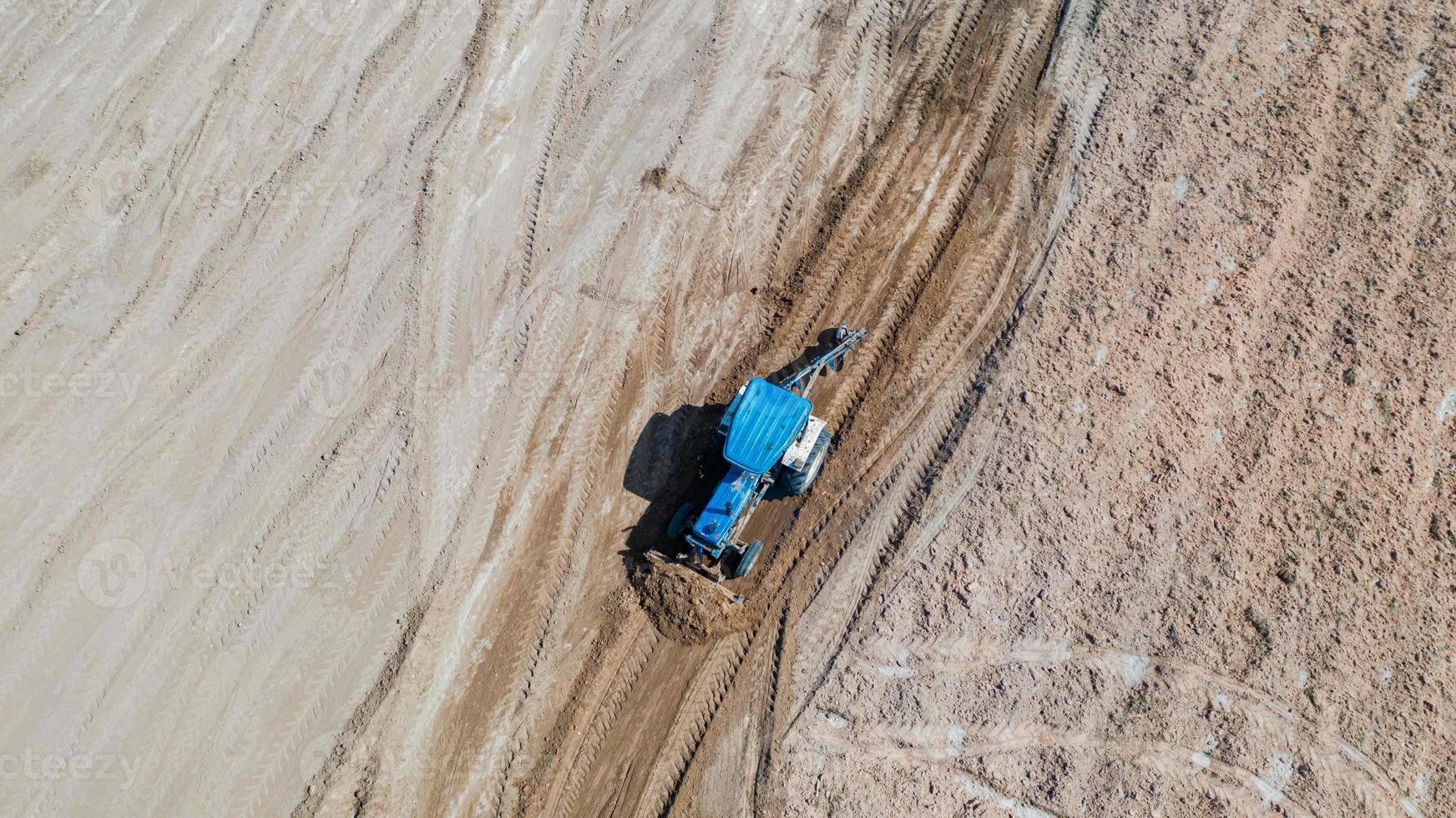 Top view of agricultural tractor vehicles working at field photo