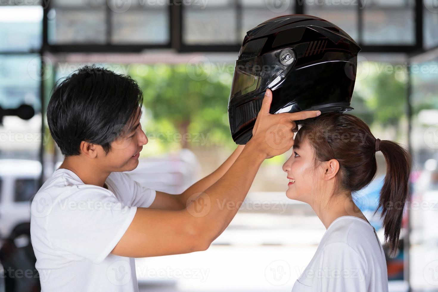 pareja que viaja de pie y con un casco de motocicleta foto