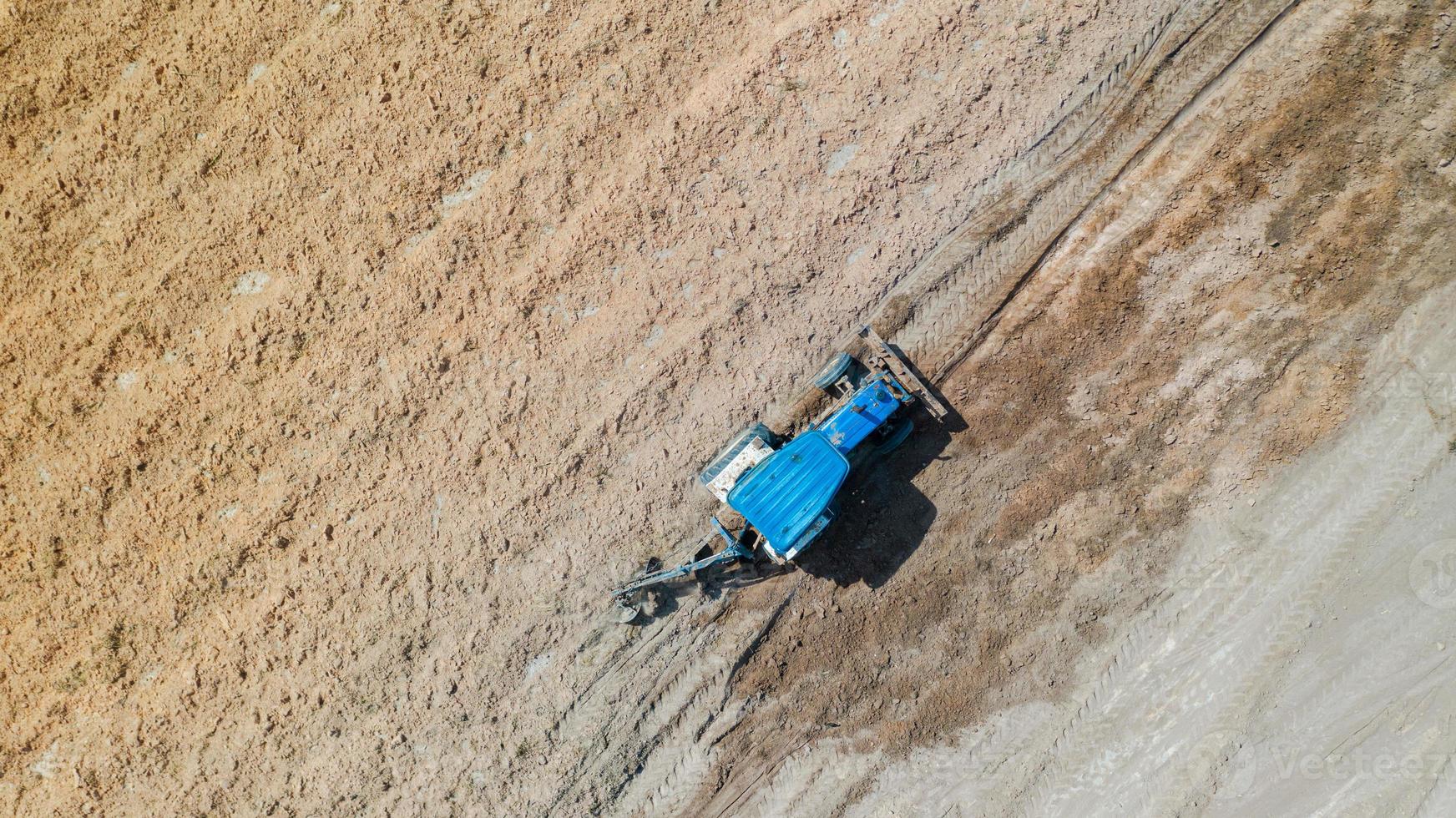 Top view of agricultural tractor vehicles working at field photo