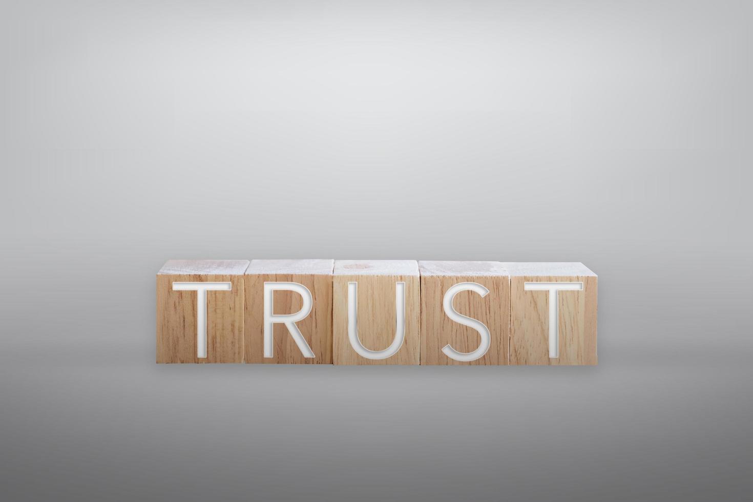 Trust word on wooden board with color background photo