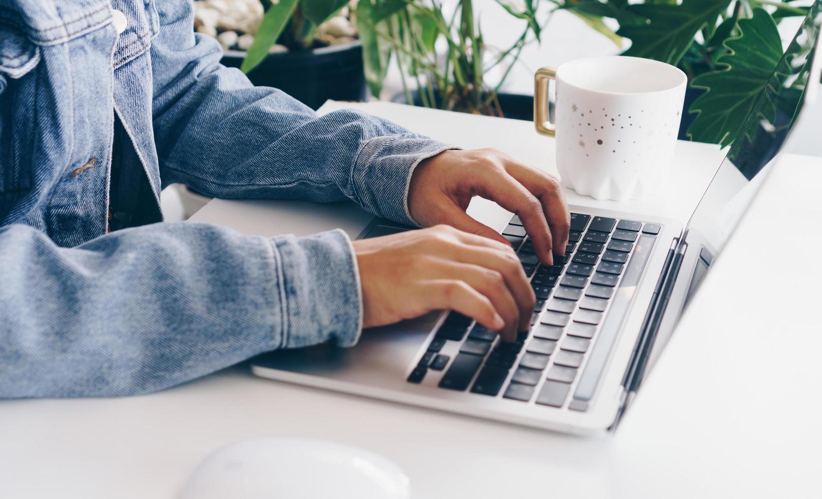 Person using a laptop to study on work desk photo