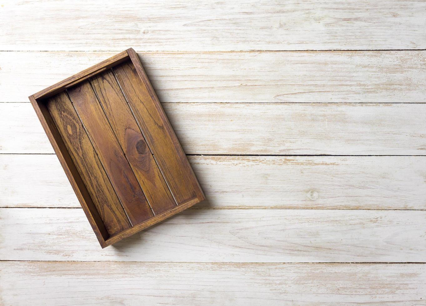 Caja de madera vacía sobre una superficie de madera blanca foto