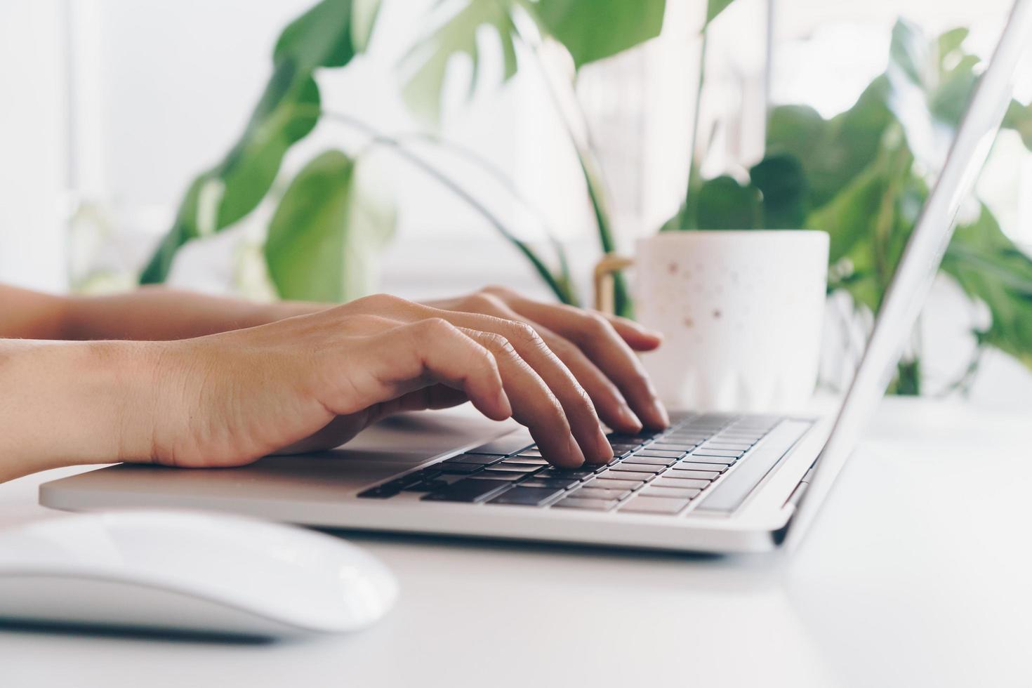 Person using a laptop to study on work desk photo