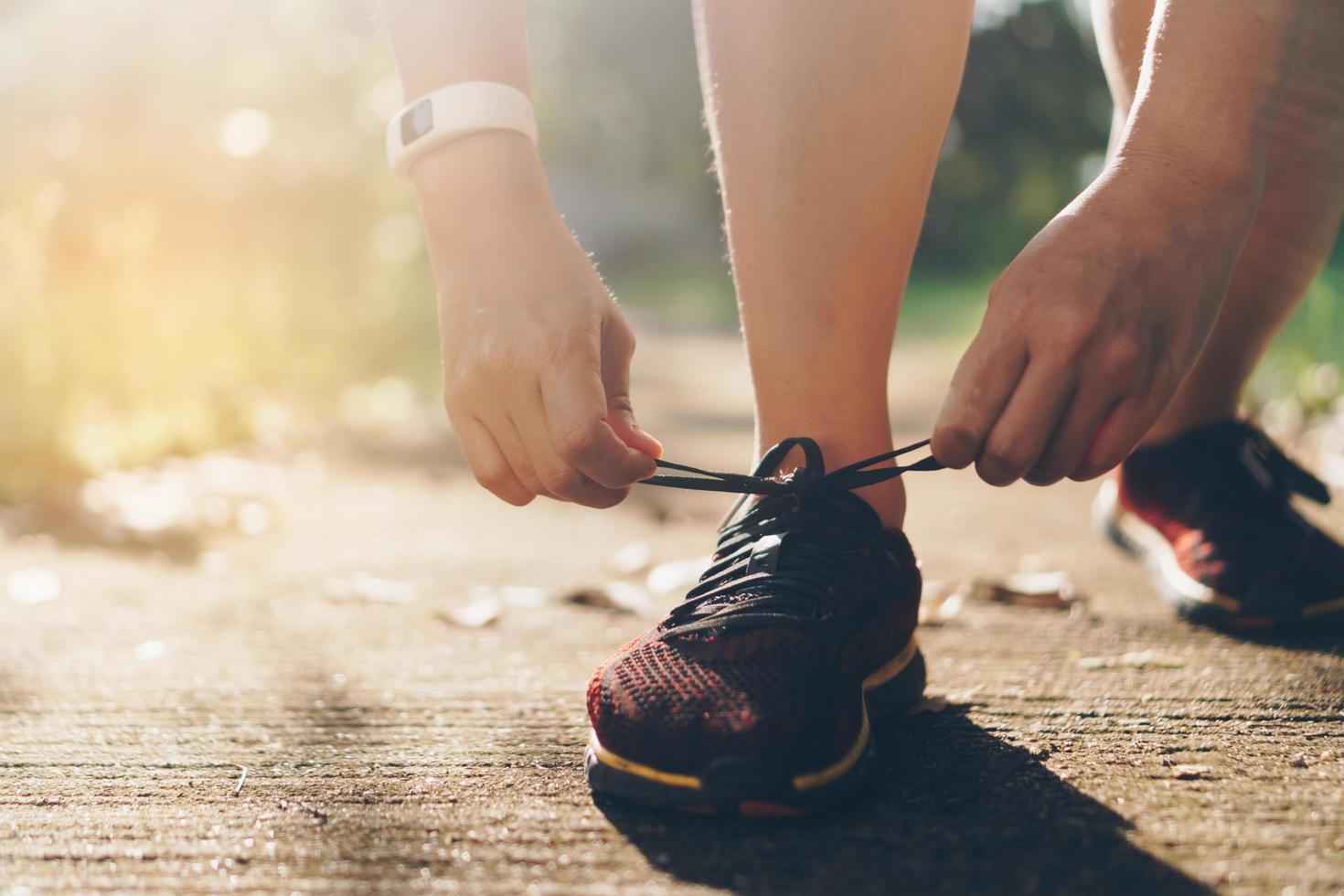 Woman wearing running shoes and running on nature green background photo