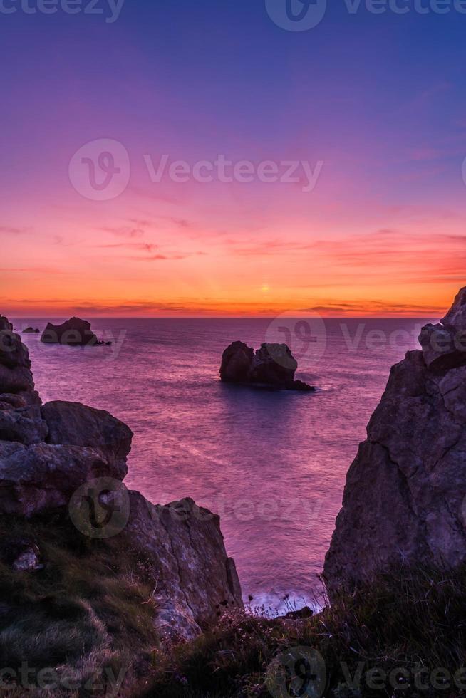 puesta de sol en la playa rocosa foto