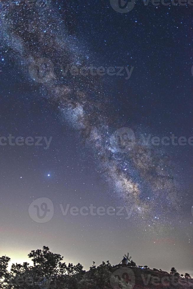 la vía láctea con un molino de viento de fondo foto