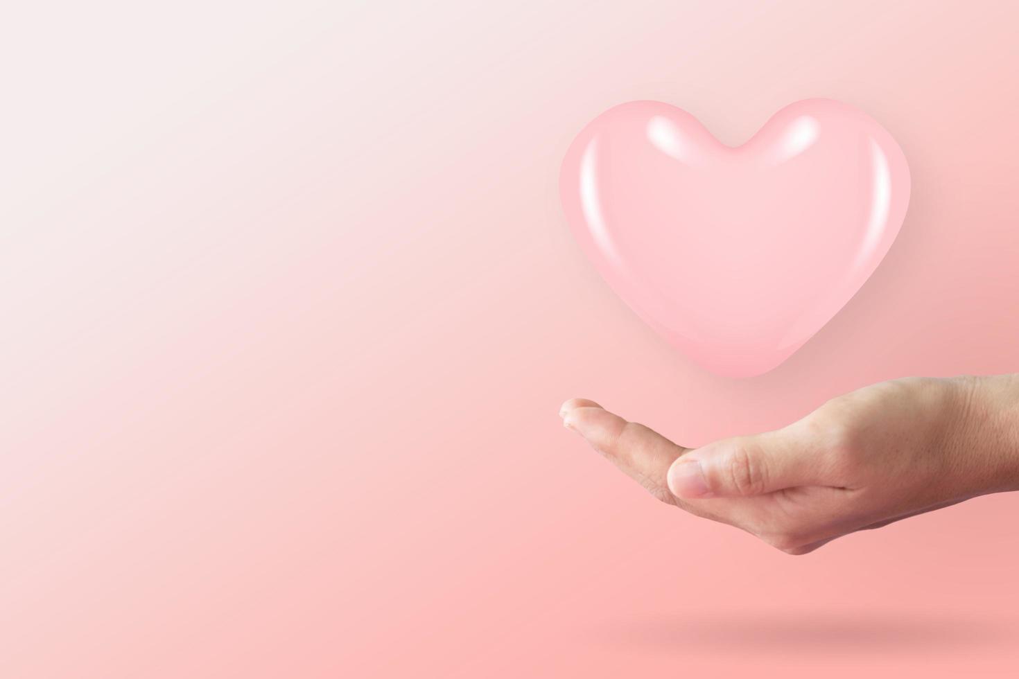 Close up of woman hands with heart with clean pastel background photo