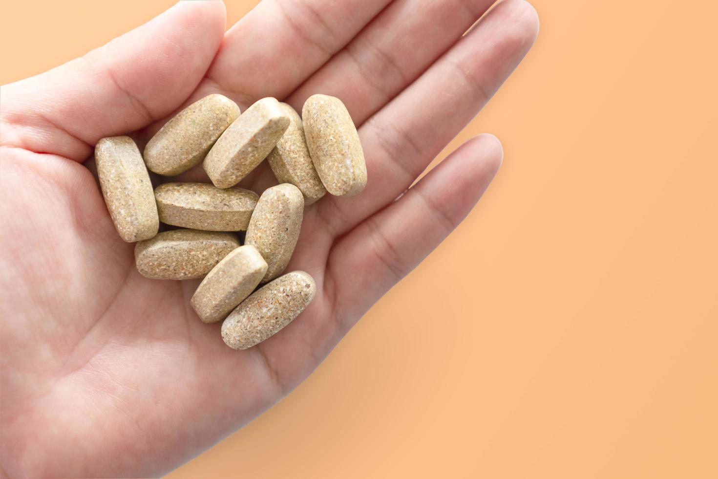 Top view of alternative organic medicine tablet on woman's hand photo