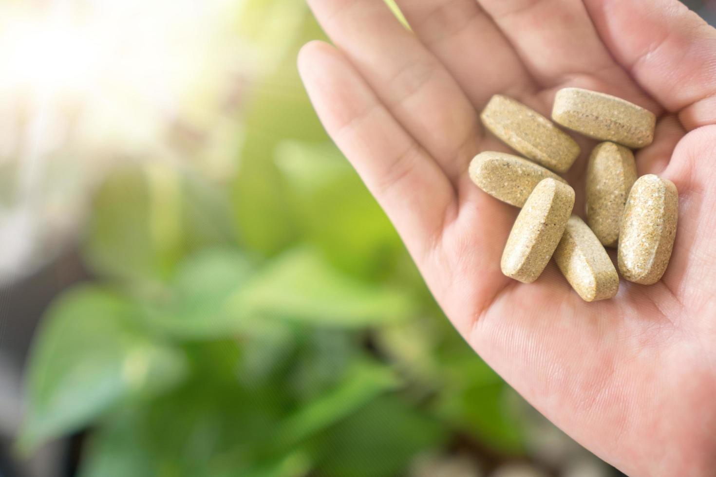Top view of alternative organic medicine tablet on woman's hand photo