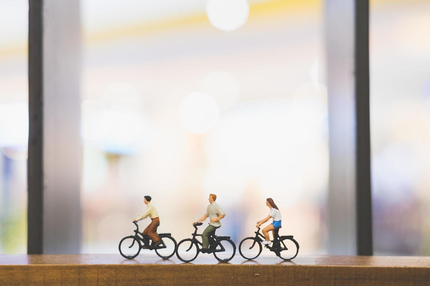 Viajeros en miniatura con bicicletas en un puente de madera foto