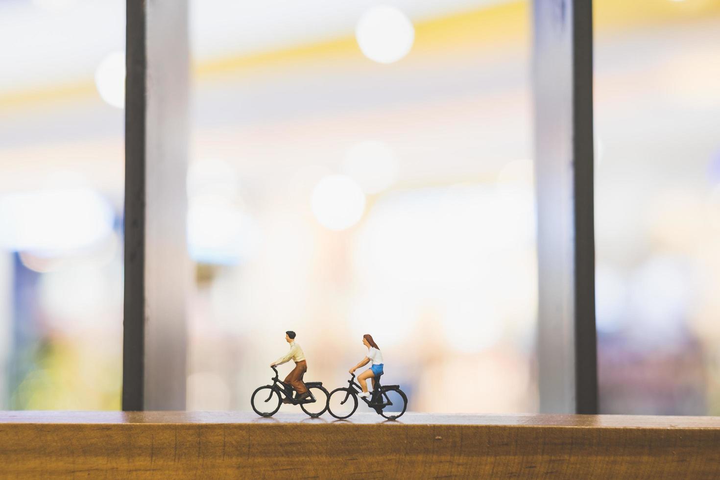 Viajeros en miniatura con bicicletas en un puente de madera foto