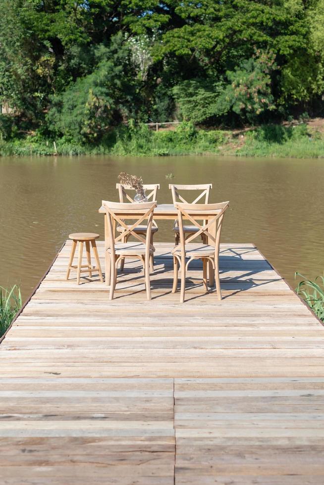 Desk and chair on a long wooden bridge near the river photo