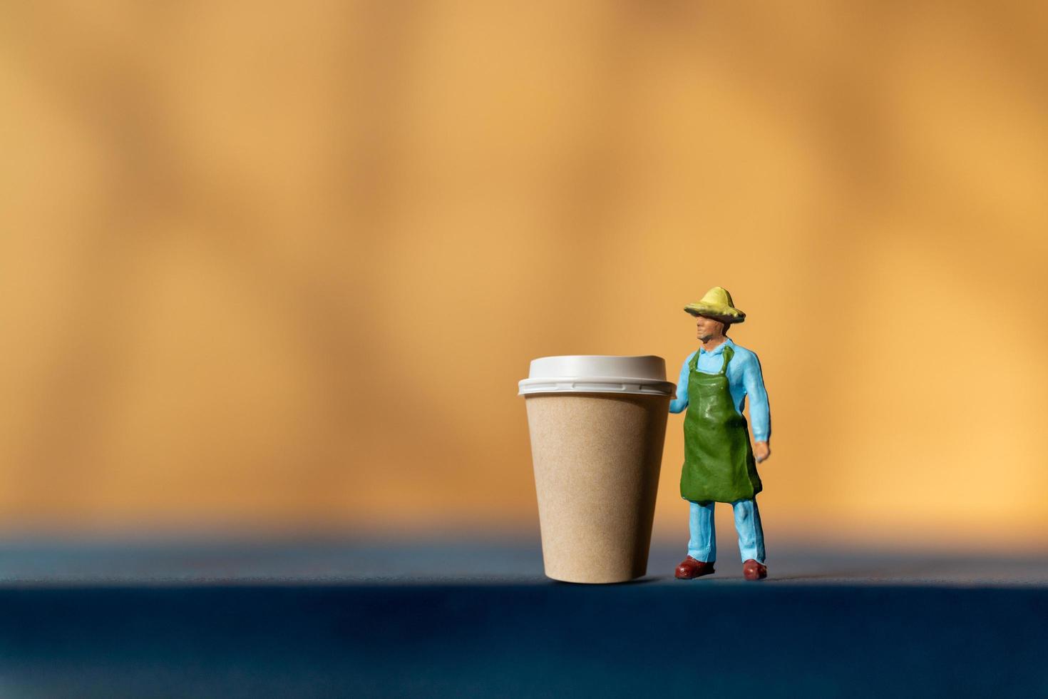 persona en miniatura y una taza de café para llevar, concepto de entrega de café foto