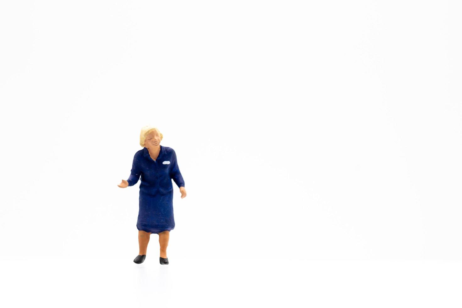 A miniature person standing on a white background photo