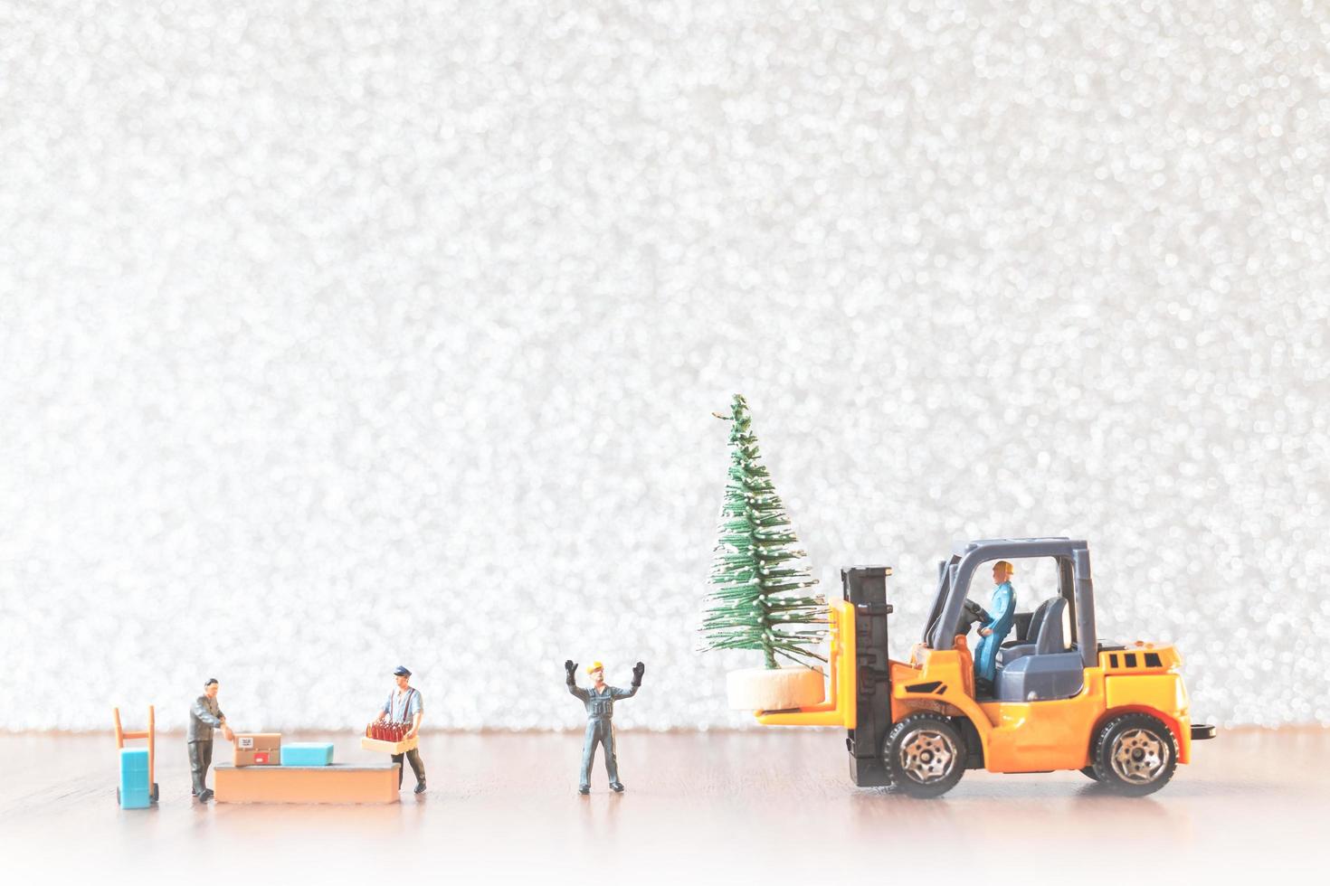 Grupo de trabajadores en miniatura preparando un árbol de navidad, concepto de adornos navideños foto