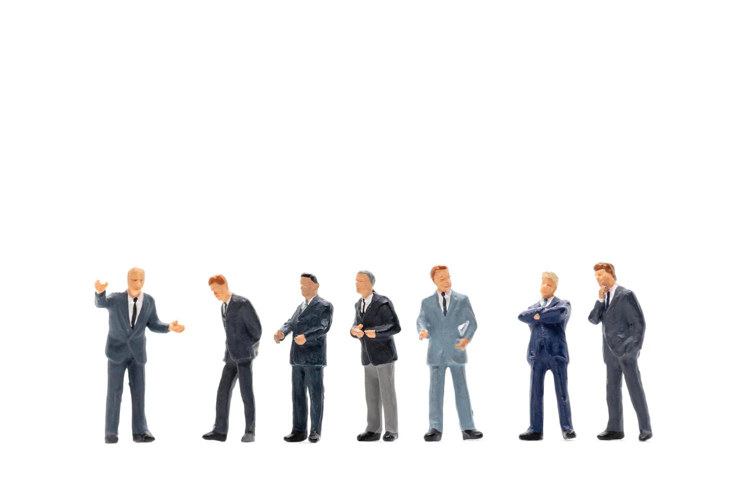 Grupo en miniatura de empresarios de pie sobre un fondo blanco. foto