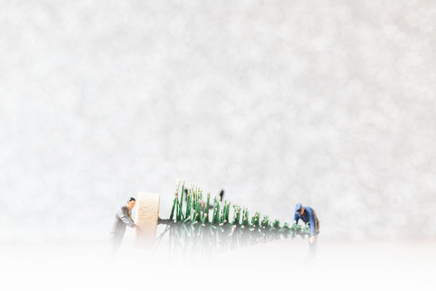 Group of miniature workers preparing a Christmas tree, Christmas decorations concept photo