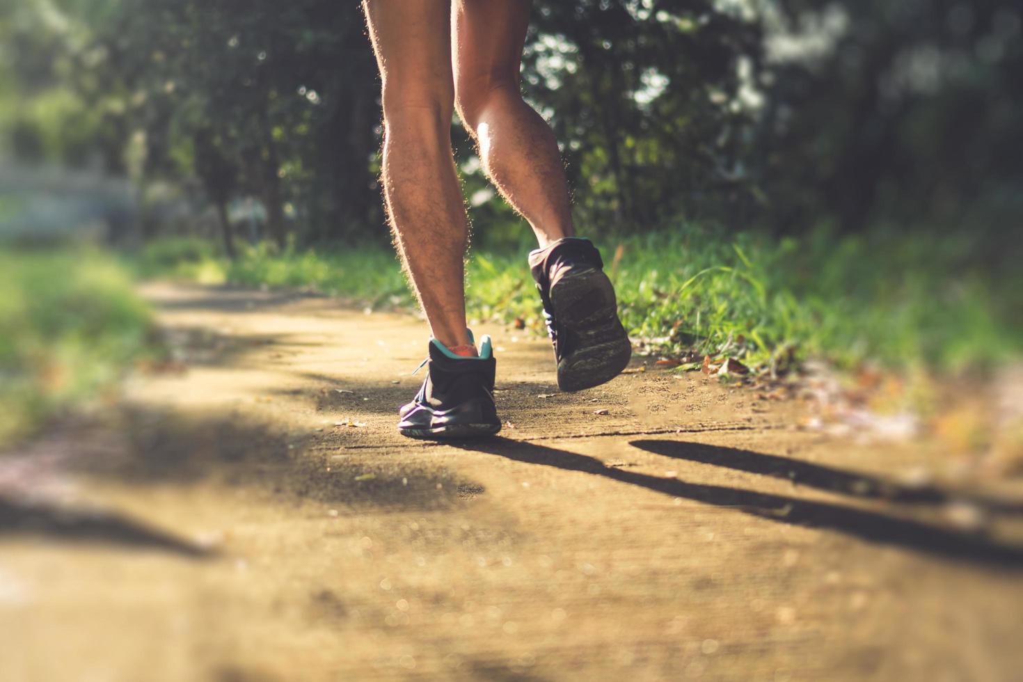 Person wearing running shoes on nature green background photo