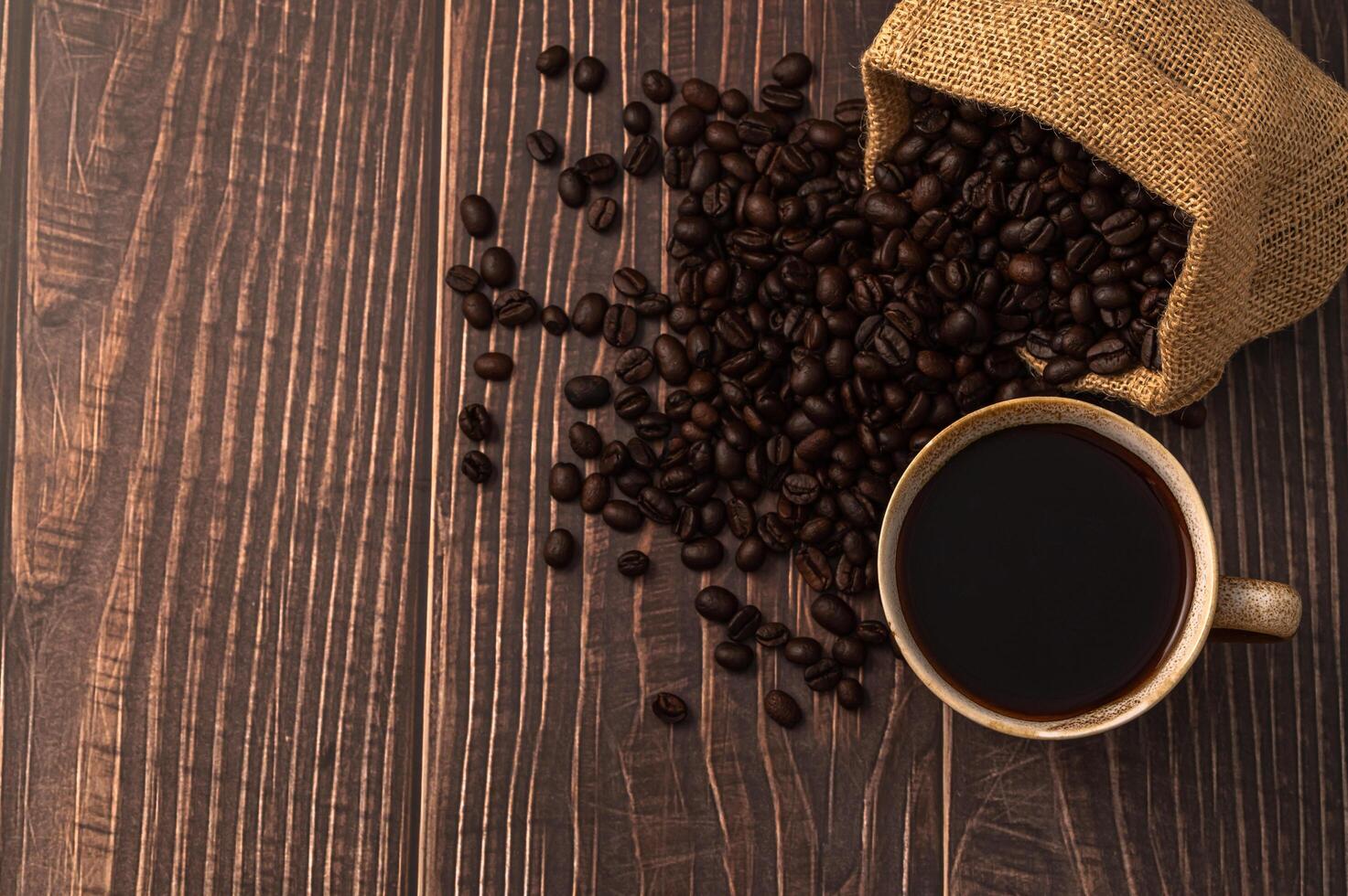 Coffee mug and coffee beans on the table photo