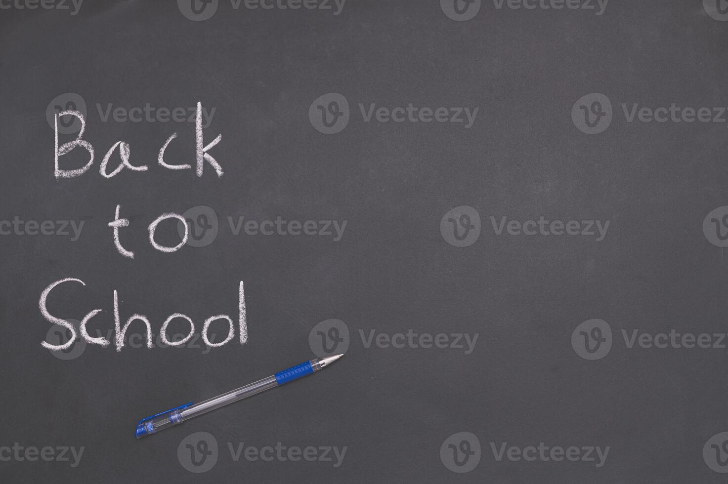 Back to school concept with pen and chalk on blackboard photo