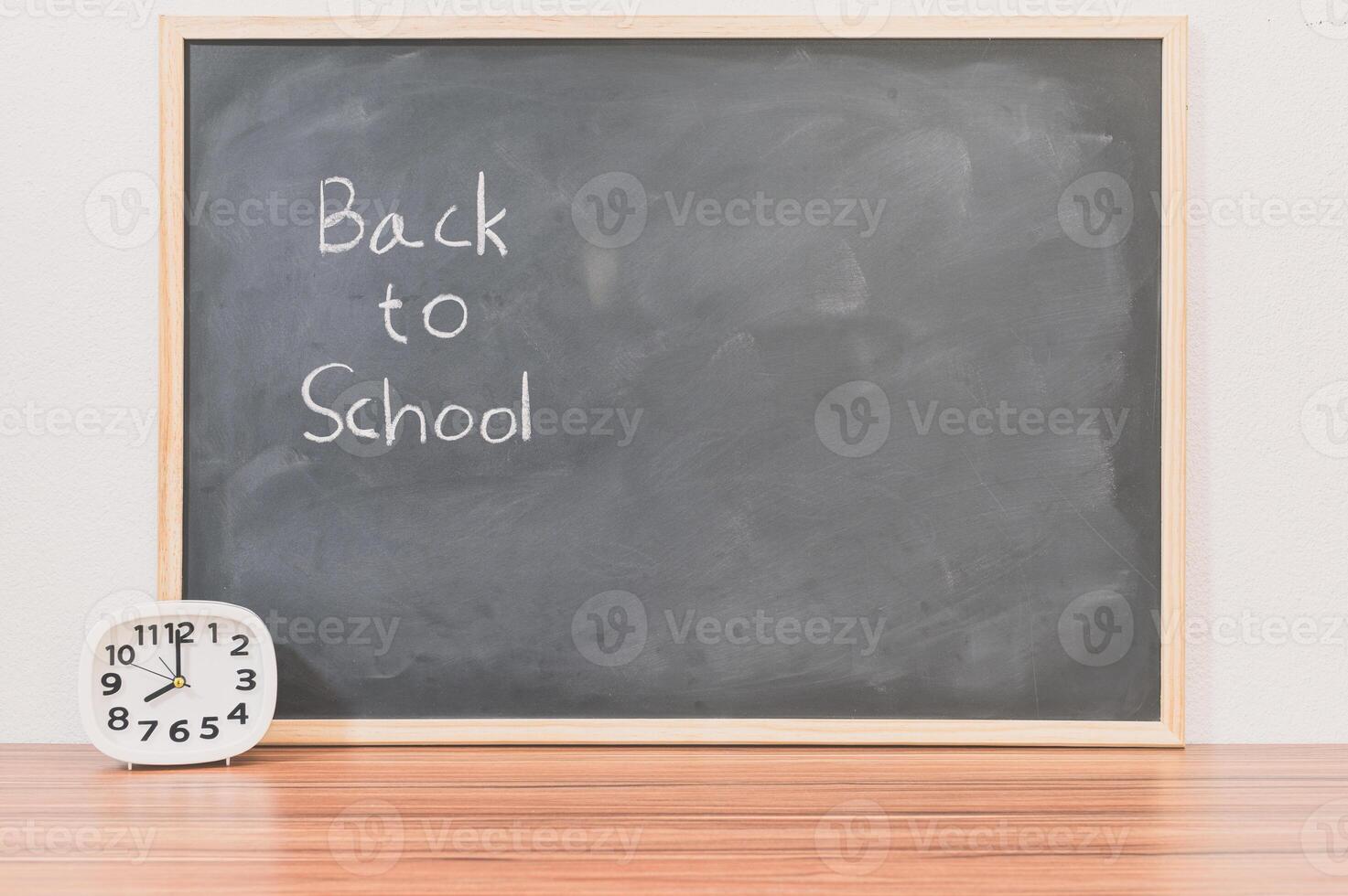 Back to school concept with chalkboard and alarm clock photo