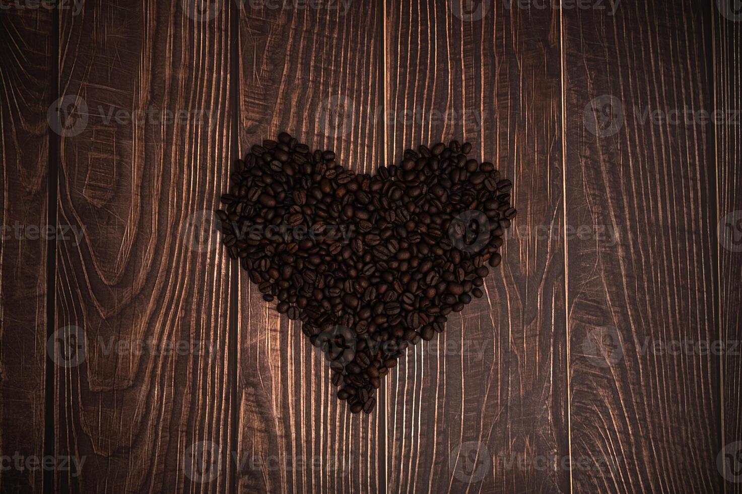 Coffee beans in heart shape on wooden background photo