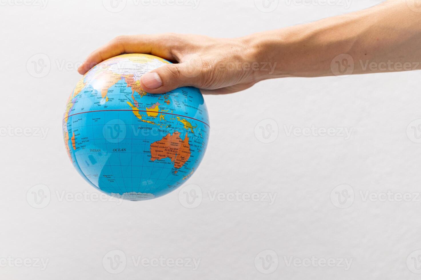 A hand holding a globe on a white background photo