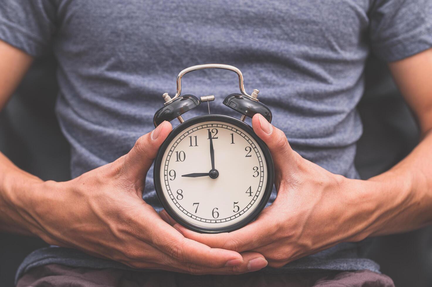 hombre sosteniendo un reloj foto