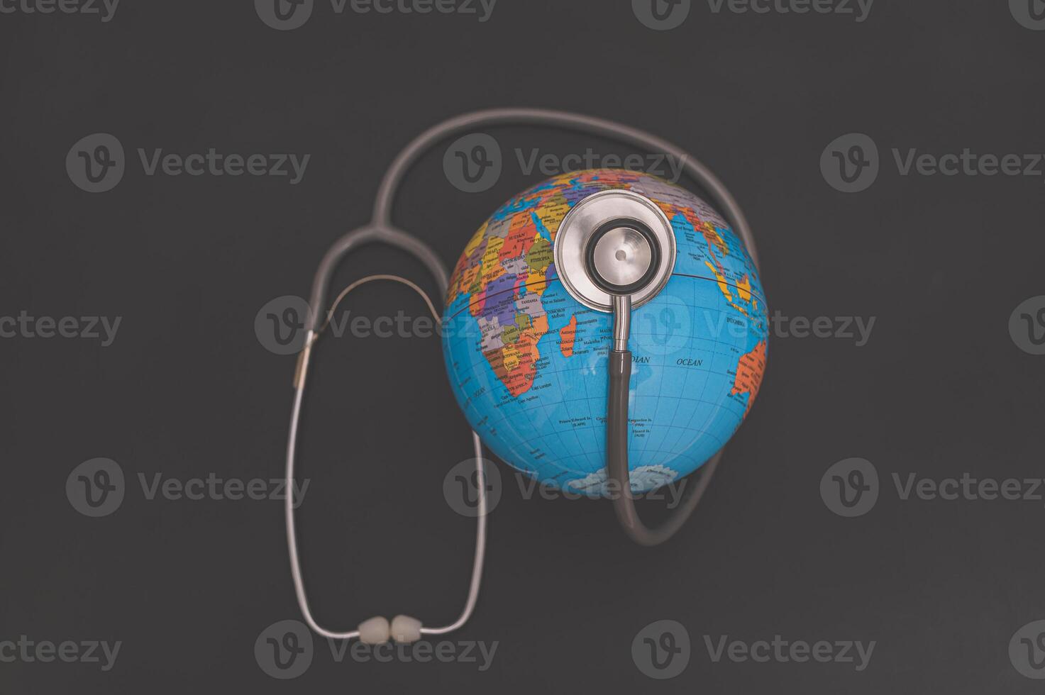 A stethoscope and globe on a black background photo