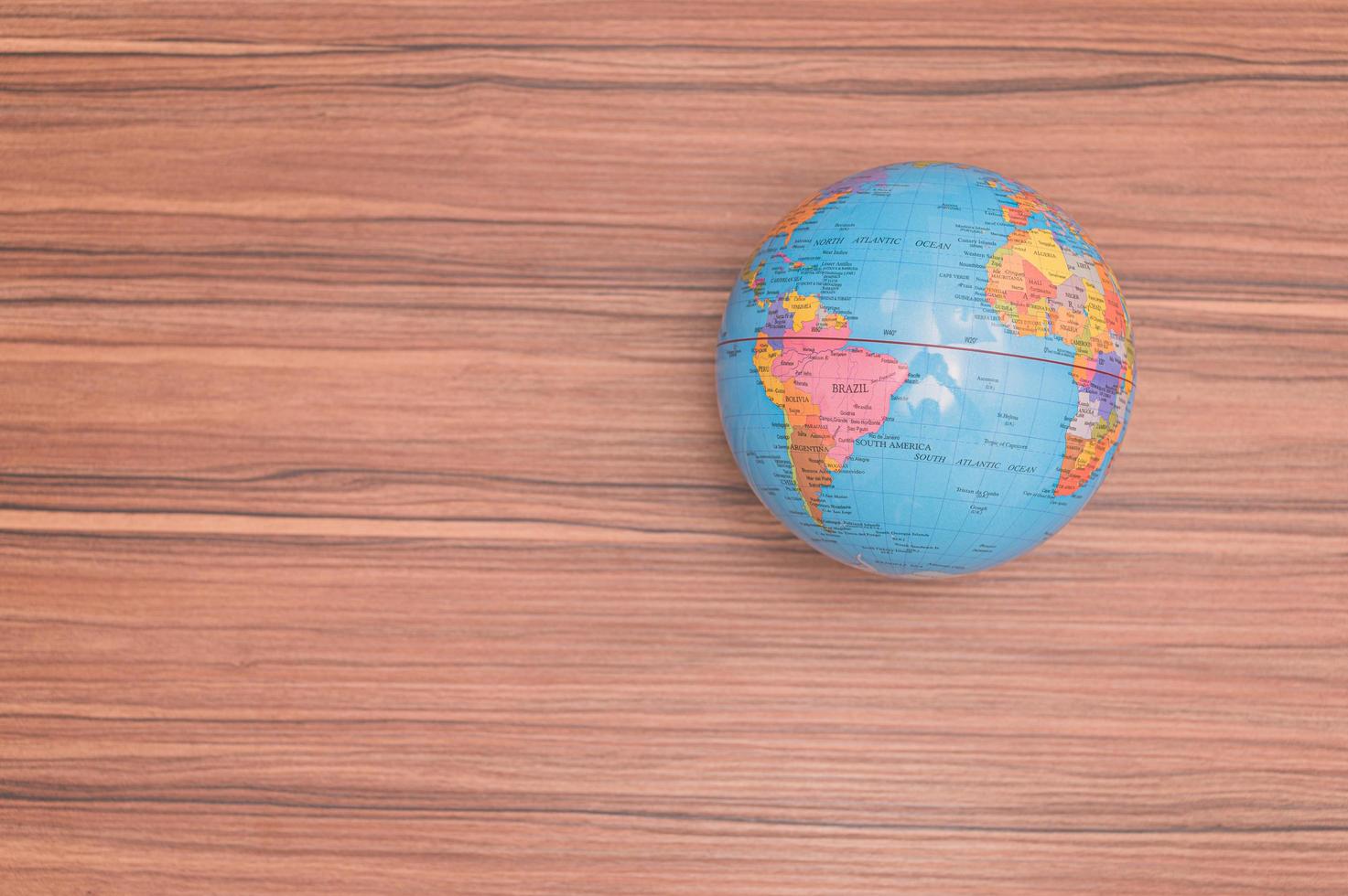 Small world globe on wooden background photo