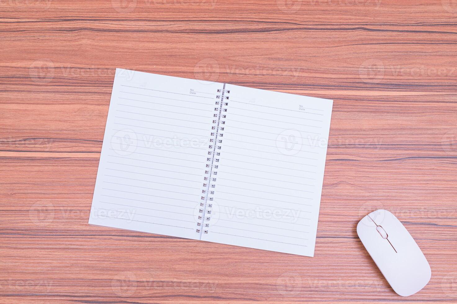 Notebook and mouse on wooden table top view photo