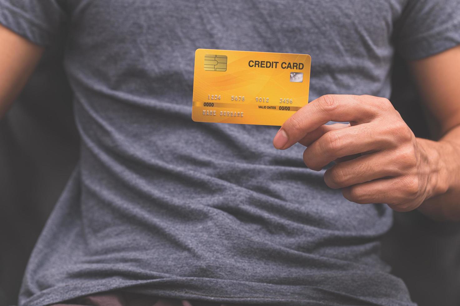 hombre sosteniendo una tarjeta de crédito en la mano foto