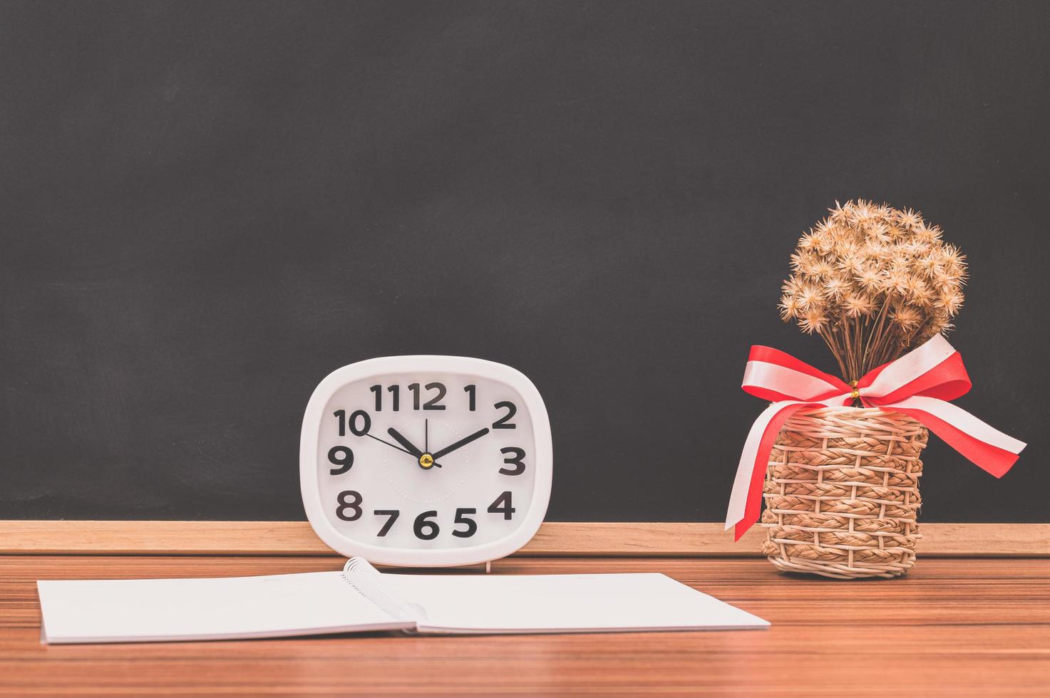 Notebook and clock on the table photo