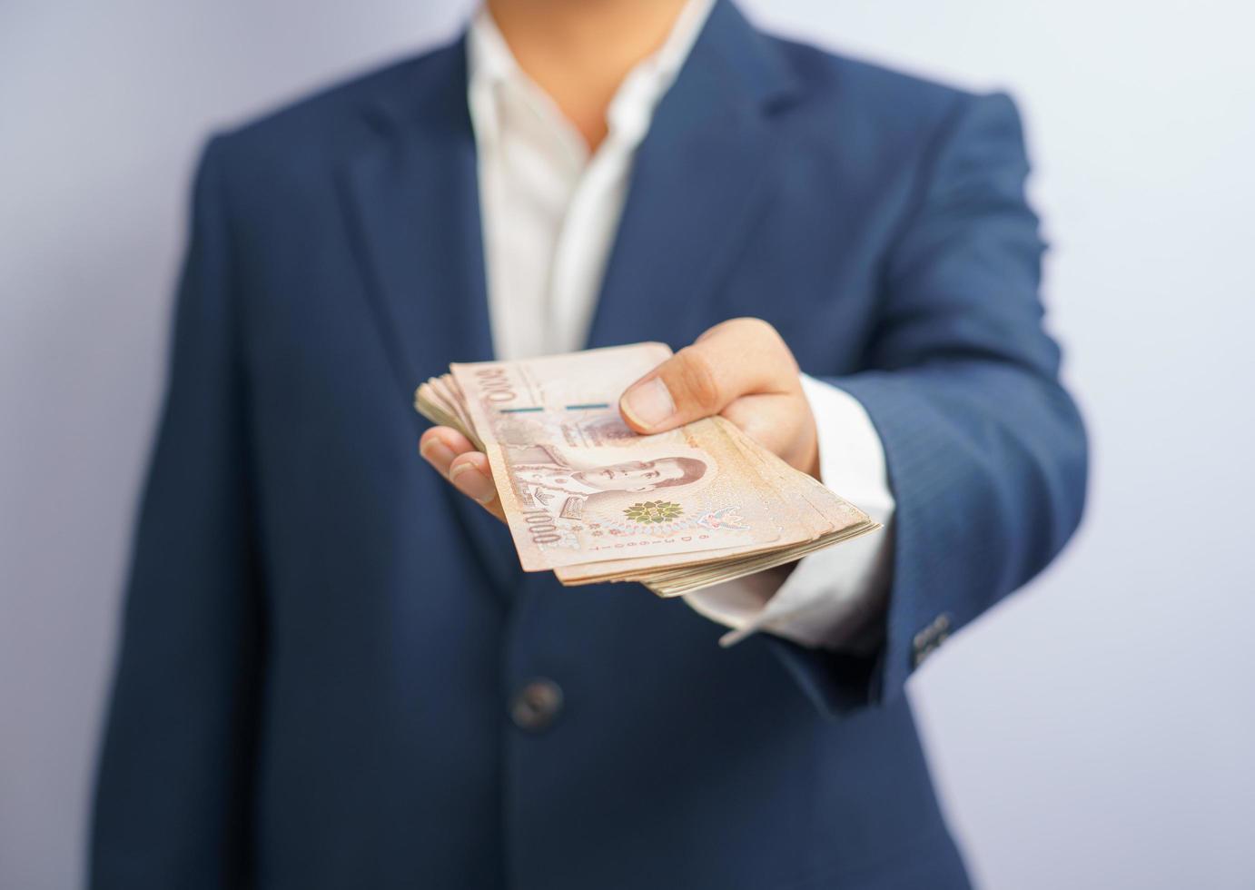 Thai money in a business man's hand photo