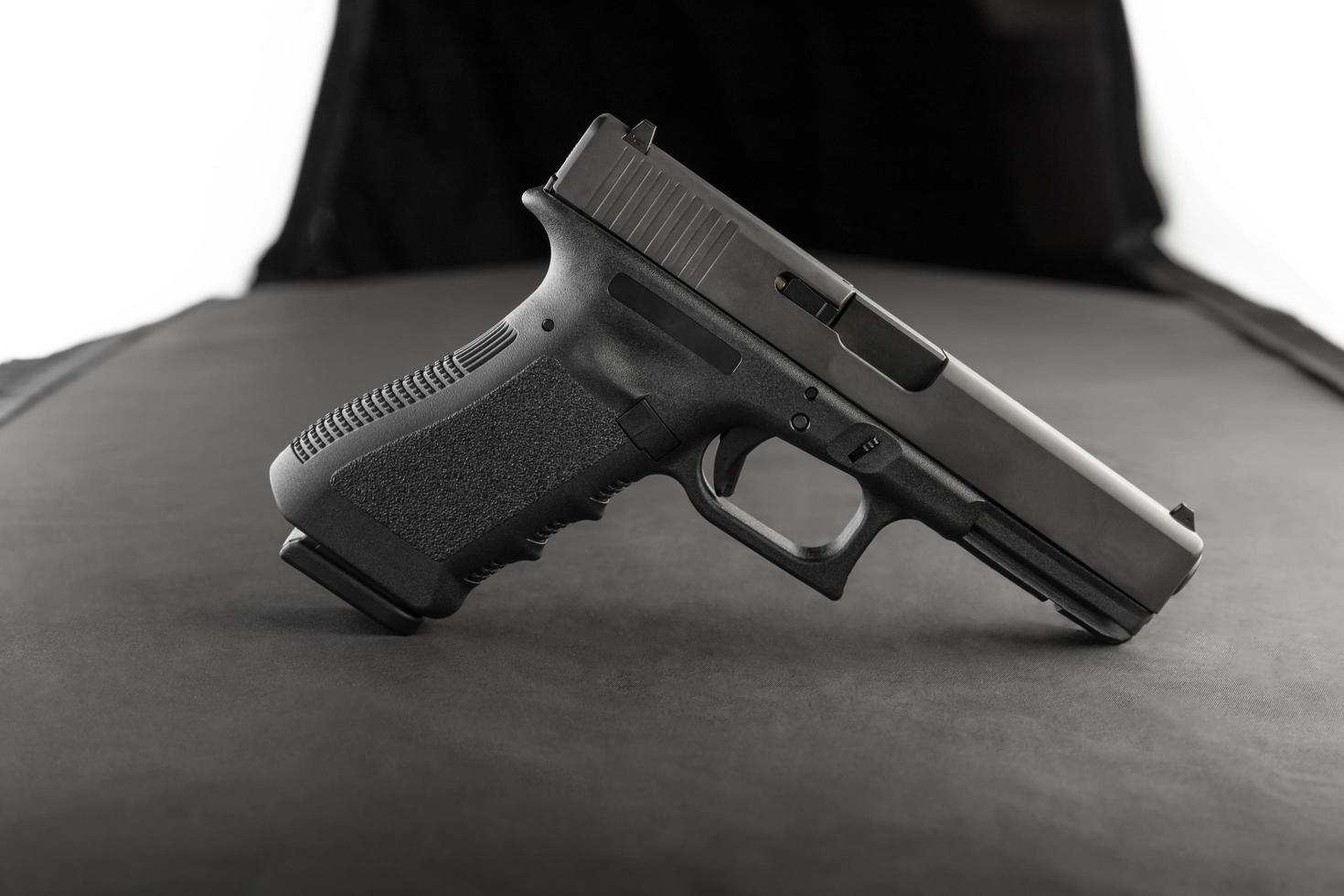 Vista lateral de pistola con iluminación artificial. foto