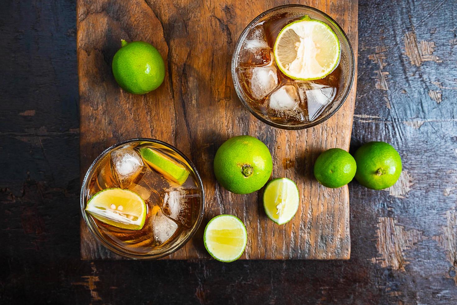 Iced tea and sliced limes on a wood tray on a wooden table photo