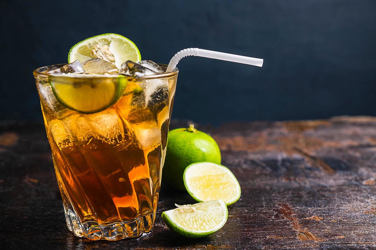 Iced tea and sliced limes on a wood tray on a wooden table photo