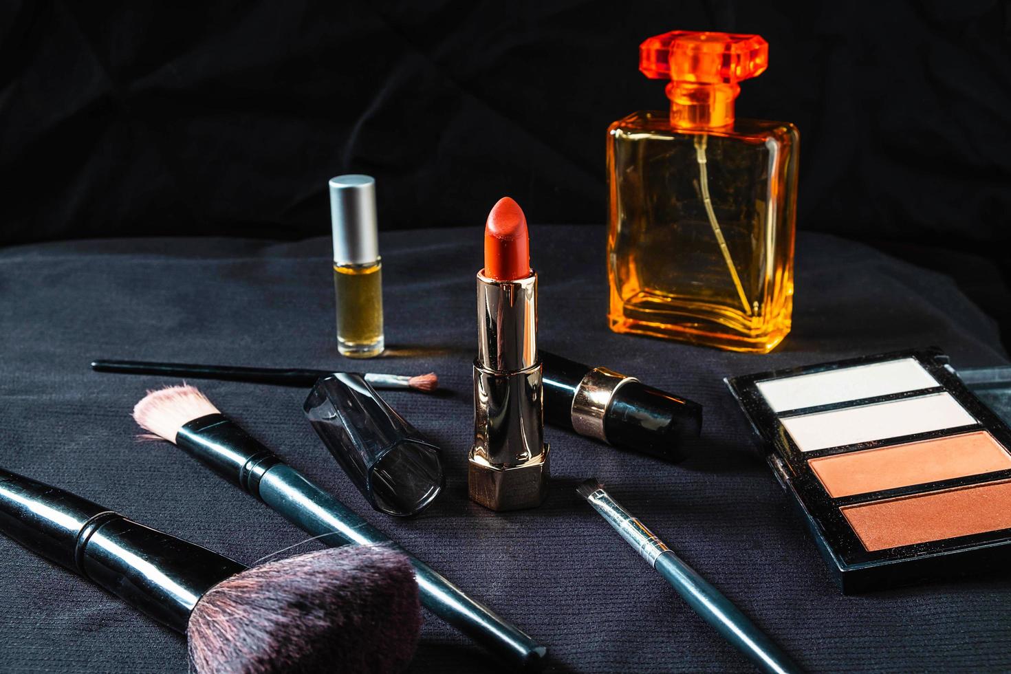 Perfume bottle and cosmetics products on a black cloth photo