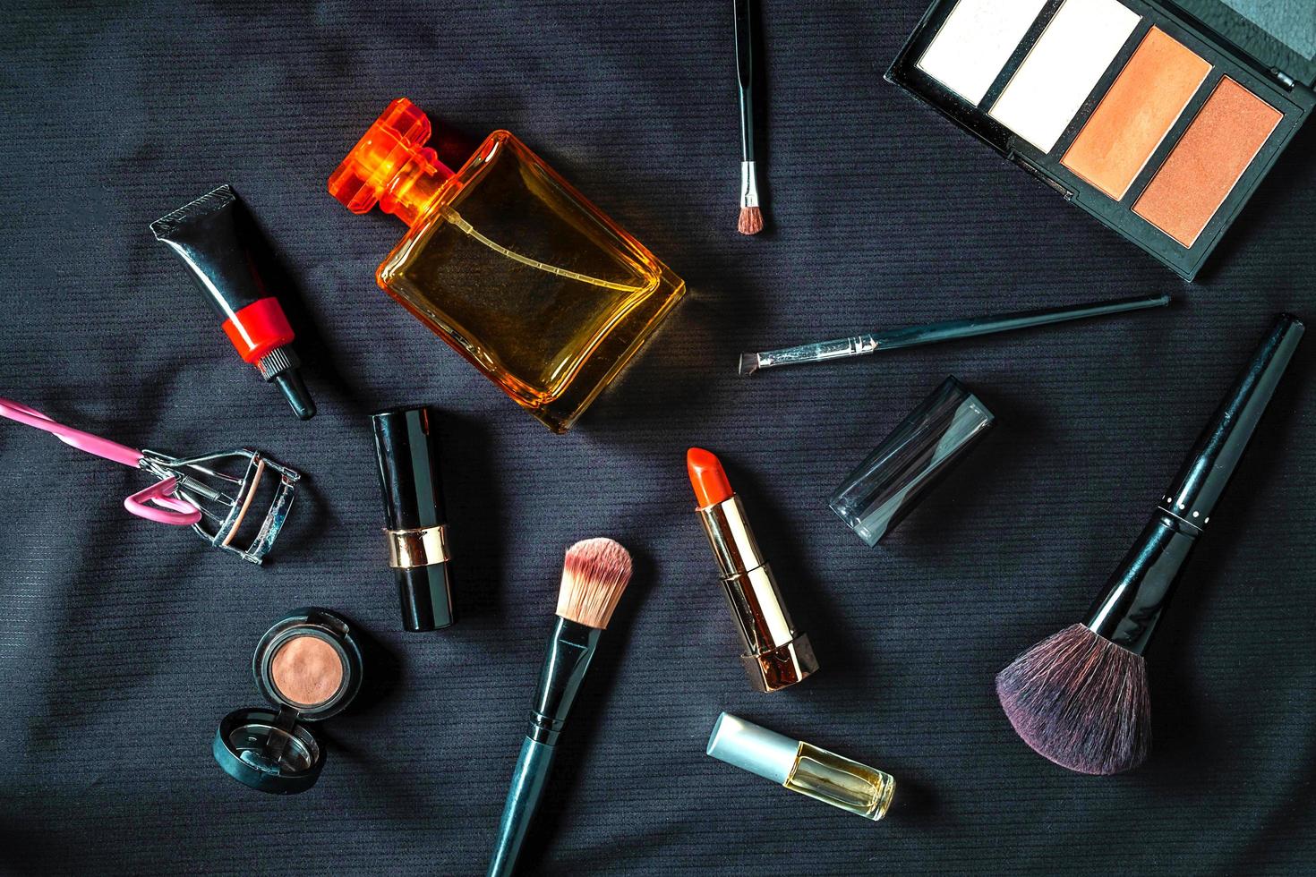 Perfume bottle and cosmetics products on a black cloth photo