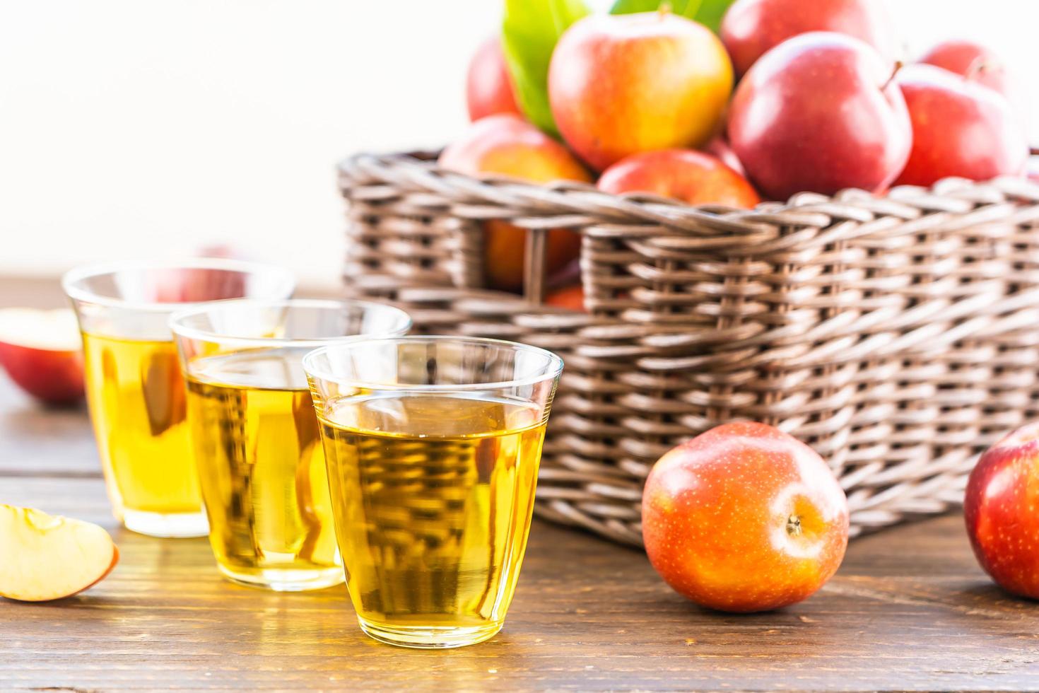 Apple juice in glasses and apples in the basket photo