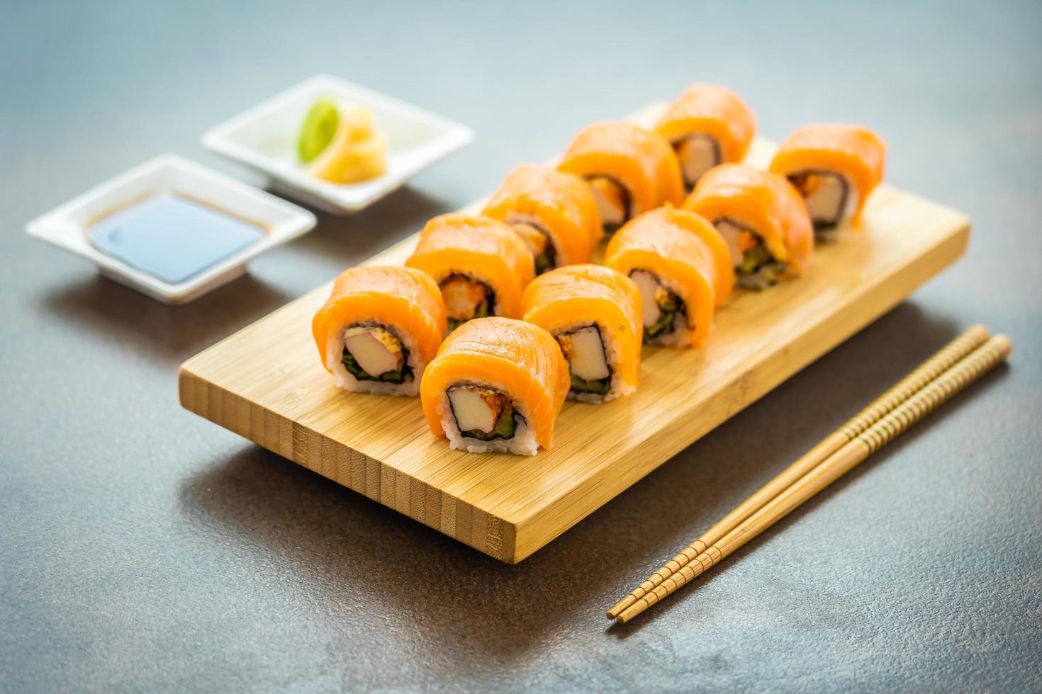Salmon sushi rolls on wood plate photo