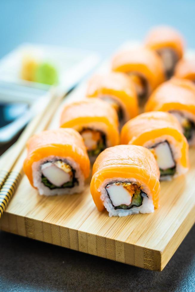 Rollos de sushi de salmón en placa de madera foto