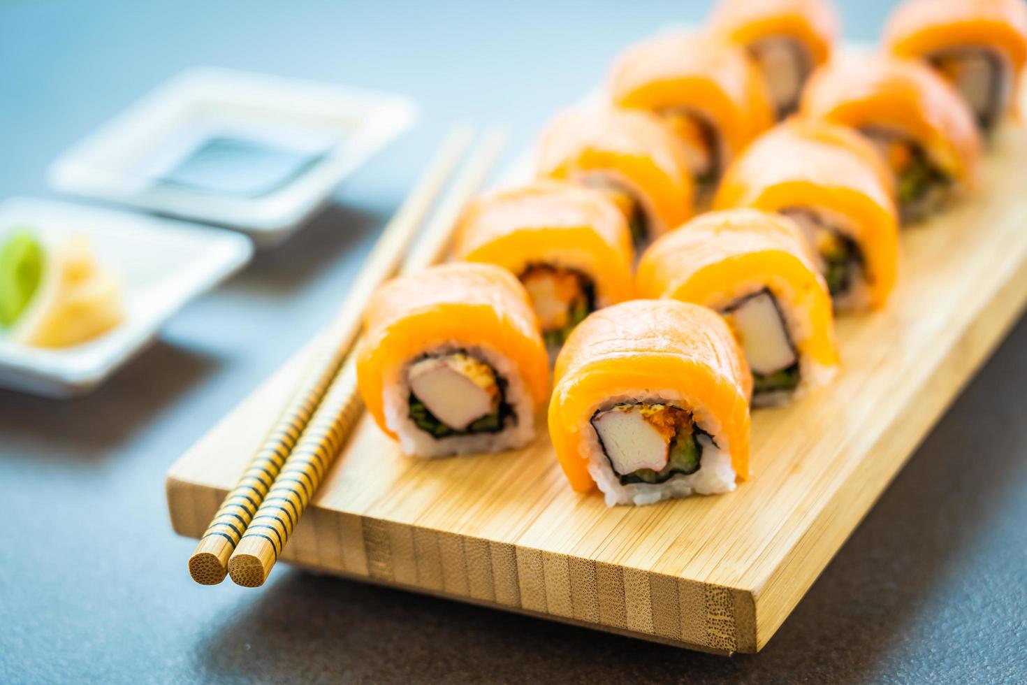 Salmon sushi rolls on wood plate photo