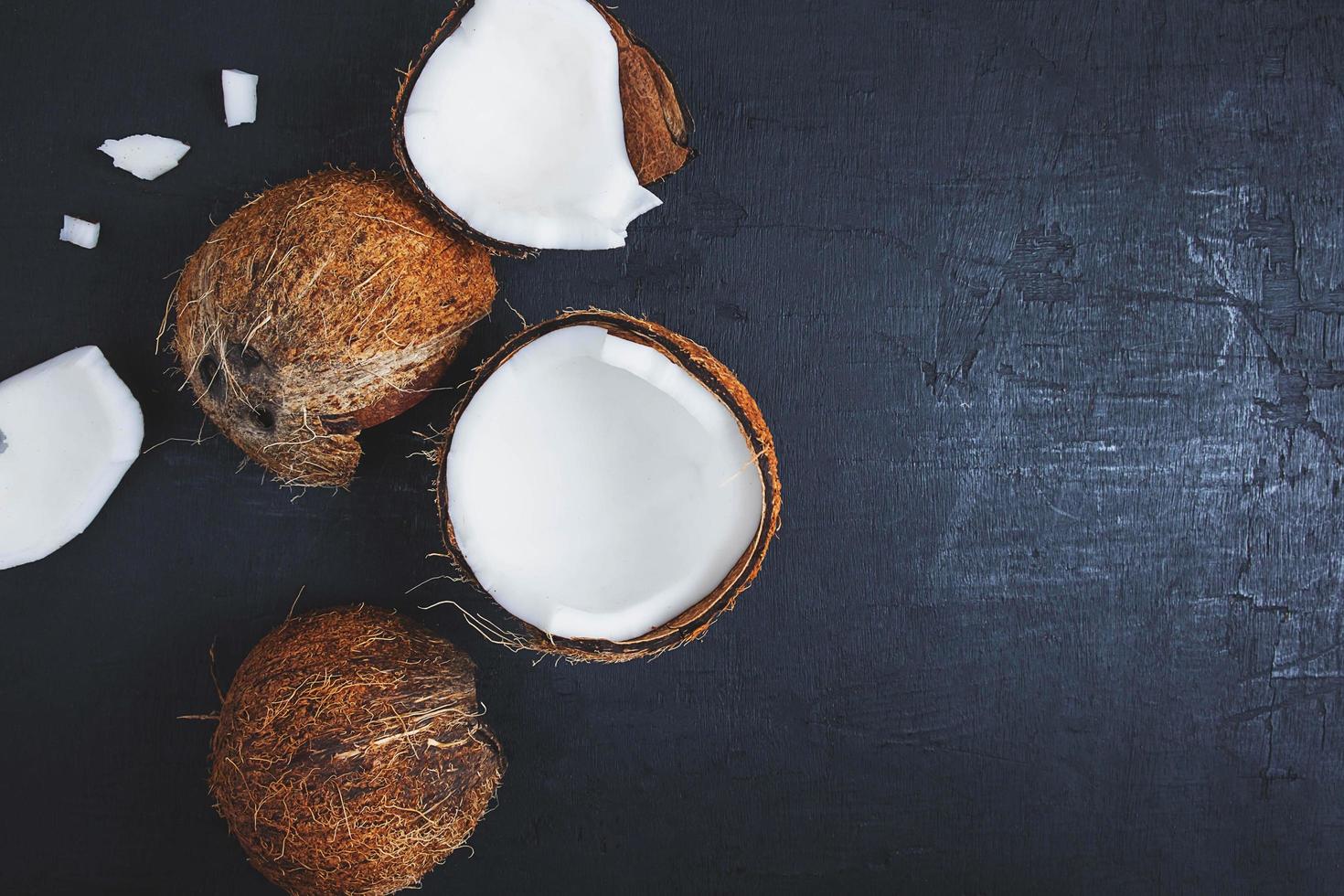 Coco cortado por la mitad sobre un fondo de tabla negro foto