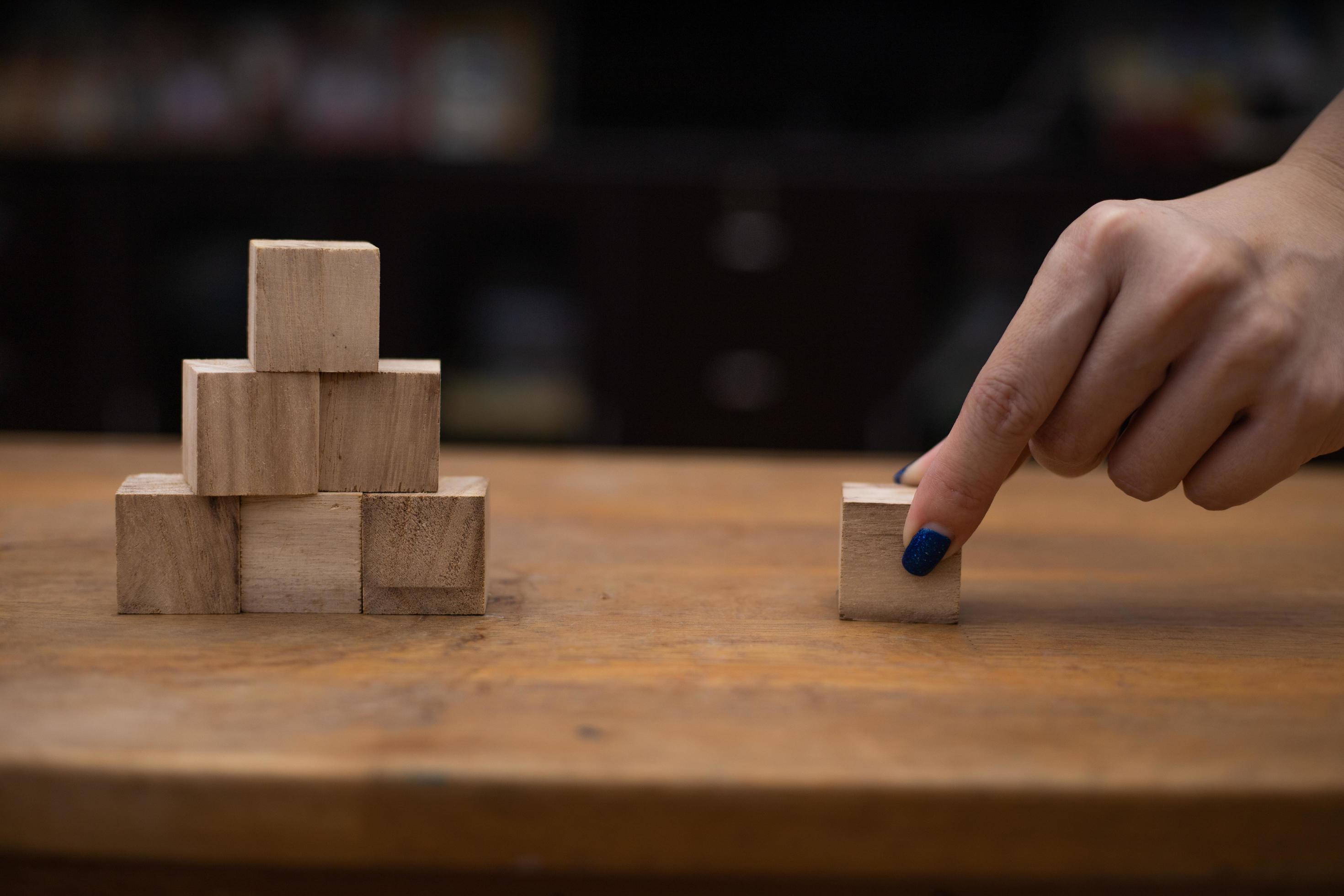 Person stacking wooden blocks 2090367 Stock Photo at Vecteezy