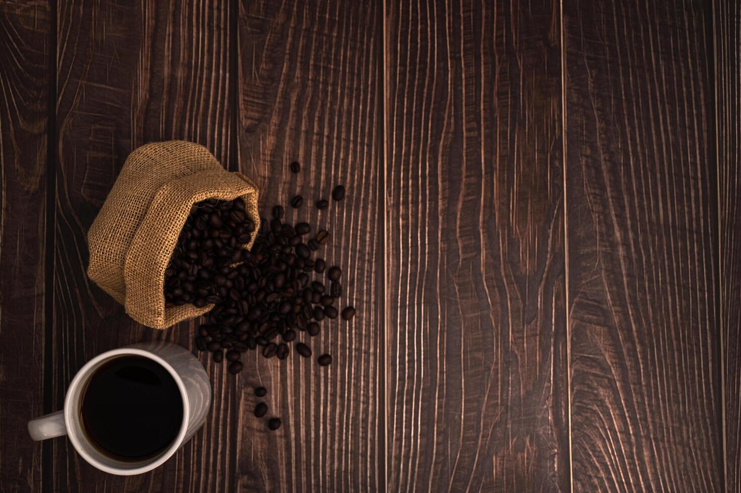 taza de café y granos de café en la mesa foto