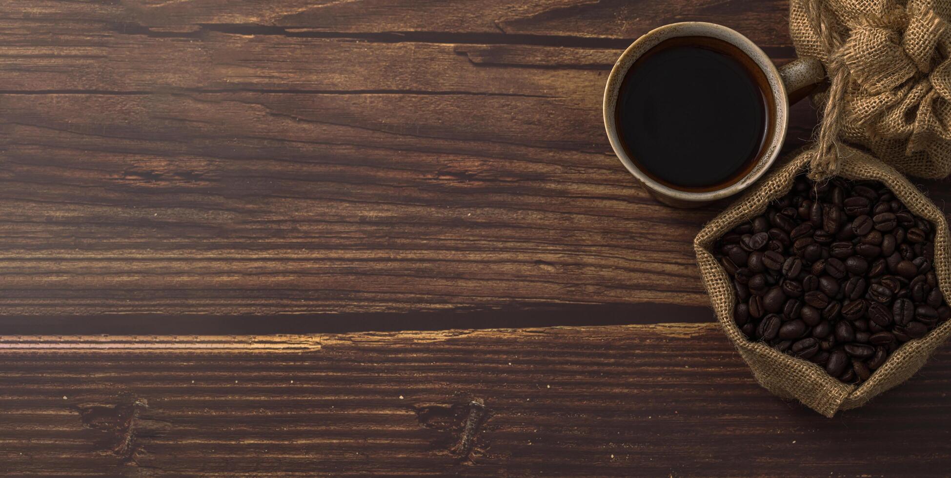 taza de café y granos de café en la mesa foto